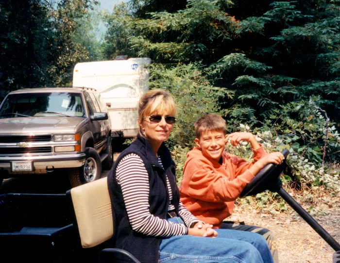 Corinne Handy and son Michael on a golf cart at Treebones, early 2000s
